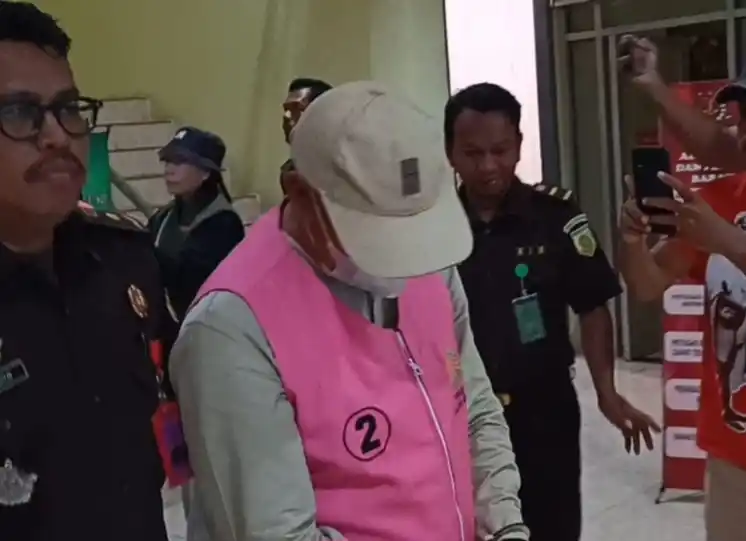 Salah satu tersangka digiring masuk ke mobil tahanan Kejari Muna, Senin (8/9/2025)