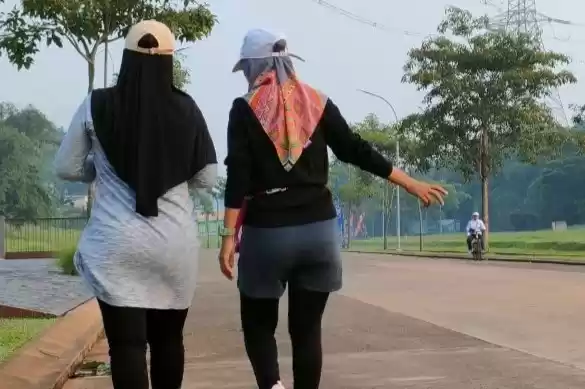 Ilustrasi - Dua wanita sedang berolahraga berjalan kaki
