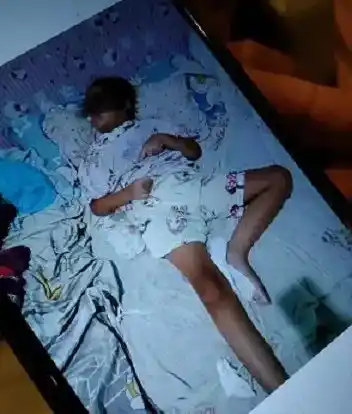 Desi Permatasari menunjukkan foto anaknya Sheena yang terbaring di tempat tidur (Foto: Dok MI)