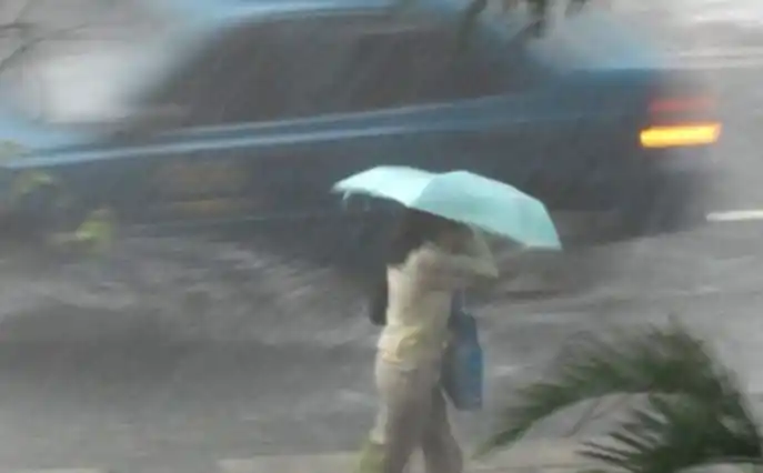 Ilustrasi  - Seorang wanita menggunakan payung ditengah hujan