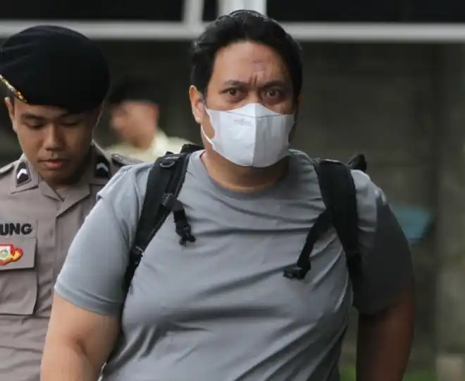 Kepala Kejari (Kajari) HSU Albertinus P Napitupulu, dikawal petugas saat tiba di Gedung Merah Putih KPK, Jakarta, Jumat (19/12/2025)