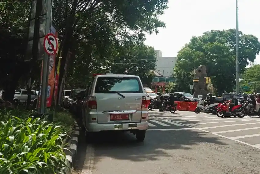 Kendaraan plat merah yang parkir sembarangan di bahu jalan depan kantor Dinkes Kota Bandung, Jawa Barat (Foto: Sugiyanto/MI)