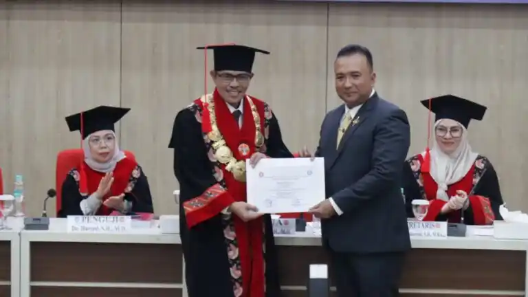 M. Edi Faryadi menerima dokumen kelulusan dari Ketua Sidang Promosi Doktor Ilmu Hukum Universitas Jambi usai berhasil mempertahankan disertasi berjudul “Tanggung Jawab Pelaku Plagiat Karya Ilmiah di Indonesia”, Kamis (3/7/2025) (Foto: Dok/MI)
