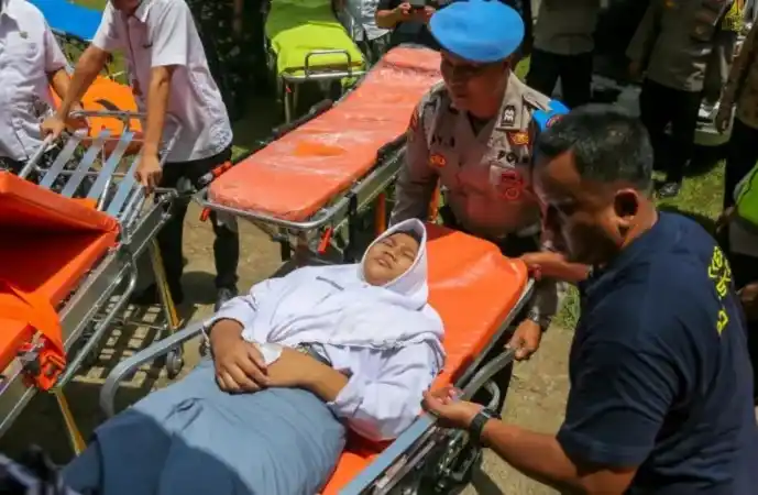 Anggota polisi dan petugas kesehatan mengevakuasi siswa yang diduga keracunan makan bergizi gratis (MBG) di SMA 2 Kudus, Kabupaten Kudus, Jawa Tengah, Kamis (29/1/2026) (Foto: Antara)