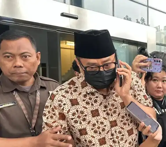 Tersangka kasus dugaan gratifikasi di lingkungan Direktorat Jenderal Pajak Kementerian Keuangan Muhamad Haniv saat berlagak menelepon seseorang ketika ditanya para jurnalis di Gedung Merah Putih KPK, Jakarta, Selasa (10/6/2025)