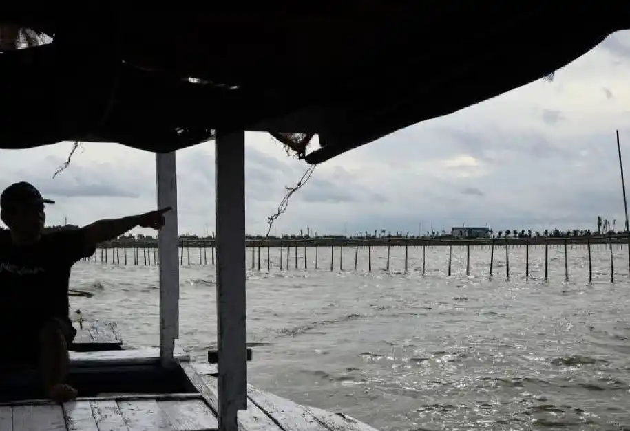 Nelayan menunjukkan pagar laut yang terpasang di kawasan pesisir Kabupaten Tangerang, Banten, Kamis (9/1/2025).