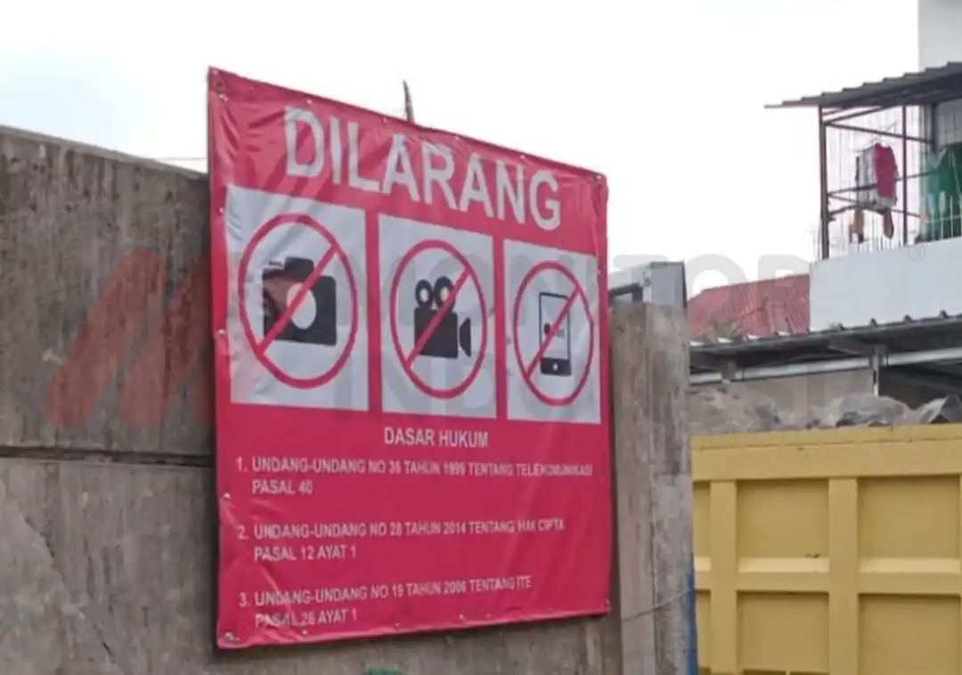 Tertulis peringatan di Papan Proyek: UU No.36 tahun 1999 tentang Telekomunikasi pasal 40. Juga UU No 28 tentang Hak Cipta pasal 12 ayat 1 dan UU No 19 tahun 2006 tentang ITE pasal 26 ayat 1.  (Foto: Dok MI)
