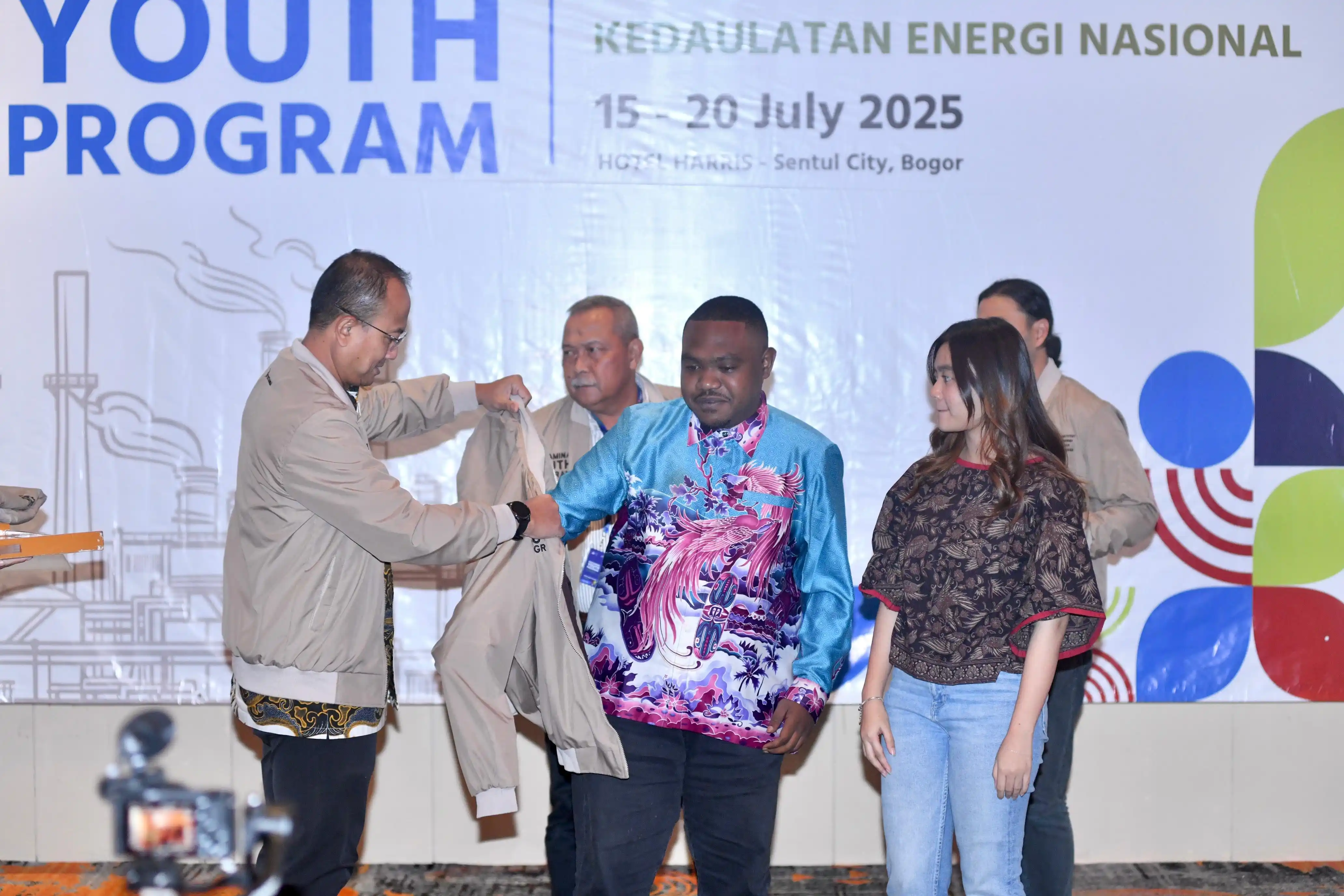 Corporate Secretary Pertamina Arya Dwi Paramita membuka acara Pertamina Youth Program secara simbolis dengan menyematkan jaket kepada salah satu mahasiswa sekaligus peserta diacara tersebut, selasa (15/7) di Ballroom Hotel Harris. [Foto: Doc. Pertamina]