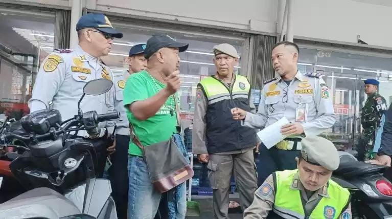 Petugas memberikan edukasi kepada juru parkir liar di minimarket di Kecamatan Tebet, Jakarta, Rabu (15/5/2024). (Foto: Antara)