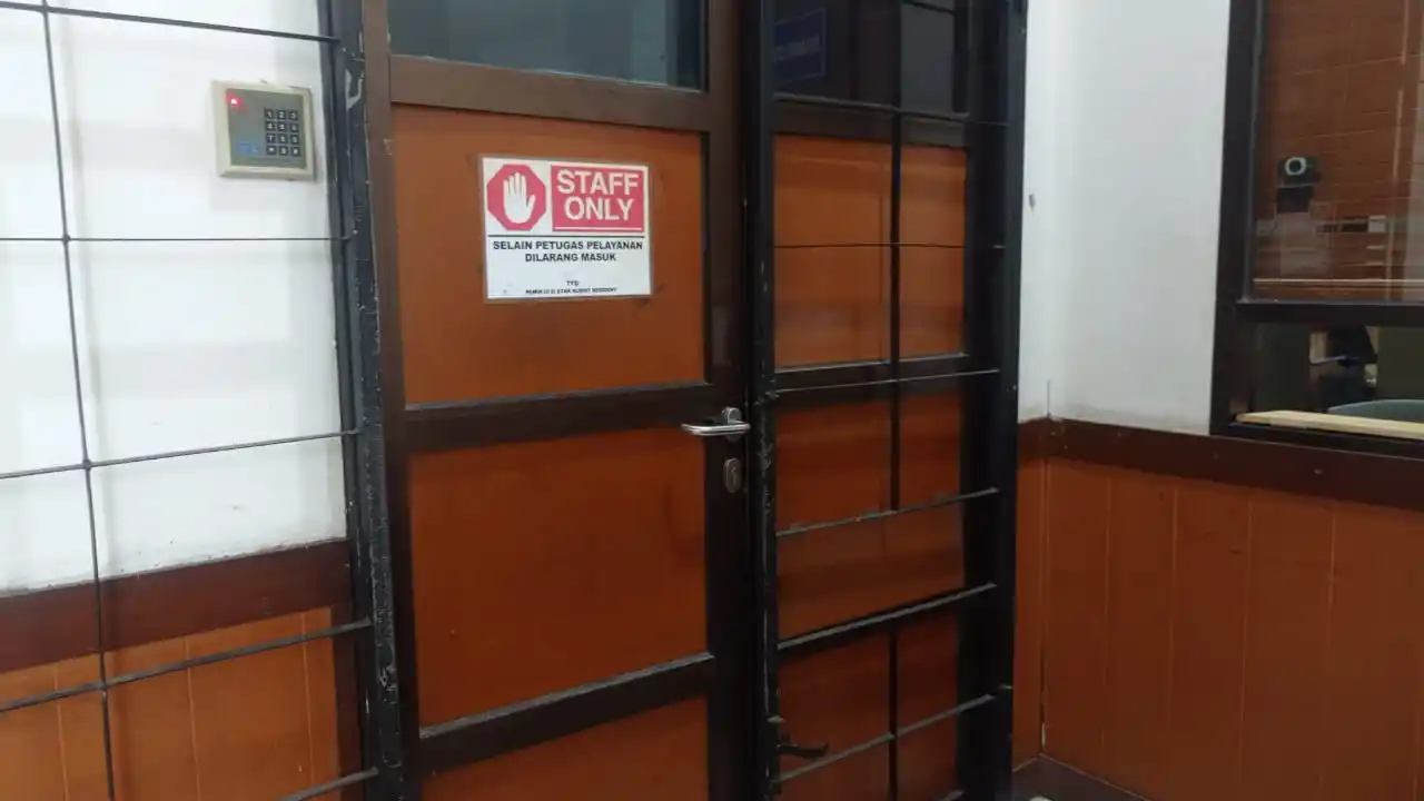 Stiker bertuliskan 'Staff Only (Selain Petugas Pelayanan Dilarang Masuk)' terpasang di pintu masuk ruang petugas Samsat Bandung Tengah, Jl. Kawaluyaan Raya, Kota Bandung, Jawa Barat. (Foto: Dok MI/Sugiyanto)