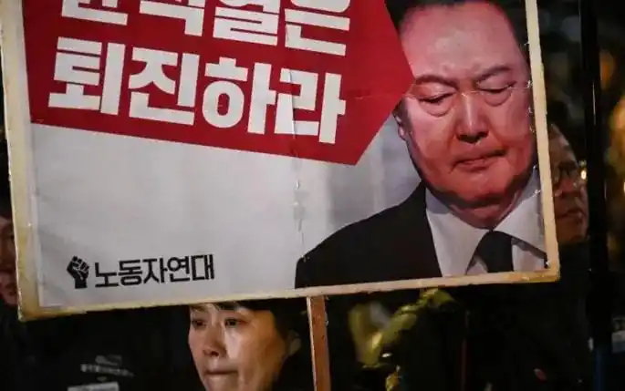 Seorang perempuan memegang plakat bertuliskan "Yoon Suk Yeol harus mundur" dalam demonstrasi Seoul pada tanggal 4 Desember 2024 (Foto: Istimewa)