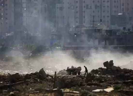 Seorang pria Palestina mengambil barang-barang dari tempat pembuangan sampah di atas puing-puing bangunan di kamp al-Bureij di Jalur Gaza tengah pada 2 Juni 2024. (Foto: AFP)