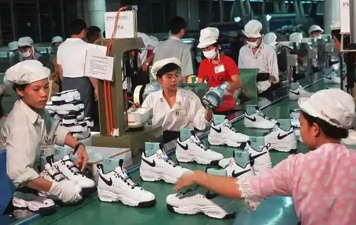 Pekerja di pabrik Nike dekat Kota Ho Chi Minh sedang merakit sepatu olahraga Nike.