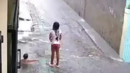 Rekaman CCTV memperlihatkan tkp bocah sedang bermain hujan hanyut terbawa arus selokan (Foto: Tangkap Layar)