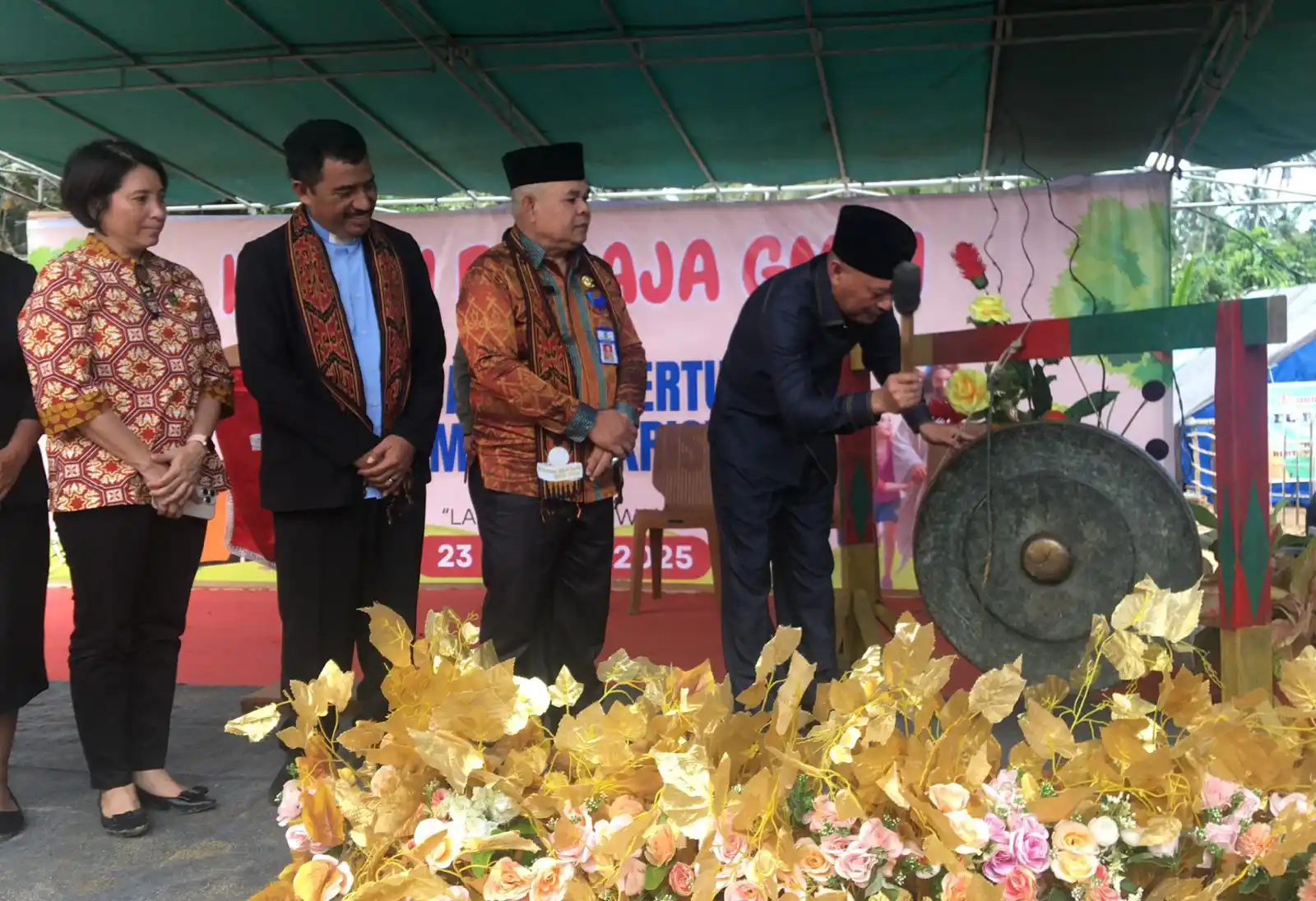 Wagub Malut Sarbin Sehe memukul gong sebagai tanda dibukanya secara resmi kegiatan Kemah Remaja GMIH Tahun 2025 di Jemaat Lahairoi, Desa Pediwang, Halmahera Utara, Selasa (24/6). (Foto: Biro Adpim)