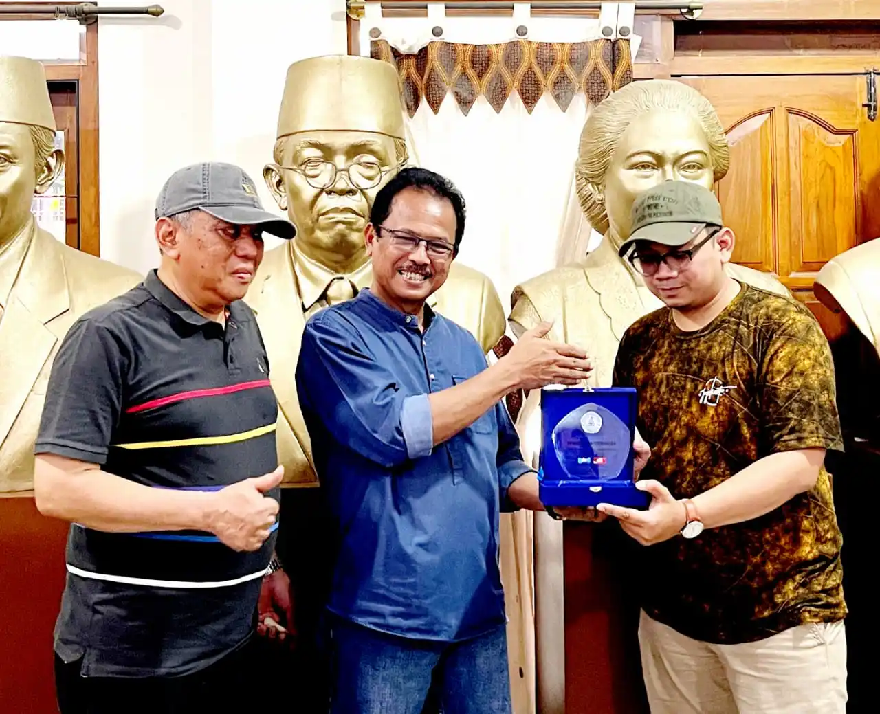 Pemberian sebuah plakat kepada pimpinan studio patung Satiaji, Dunadi (tengah), oleh Wakepsek Jihan (kanan) dan disaksikan oleh Kepsek, Akhmad Nidom (paling kiri). (Foto: Dok MI/Gatot Eko Cahyono)